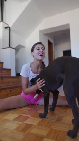 a woman playing with her dog indoors