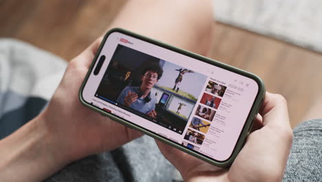 person watching youtube video on mobile phone