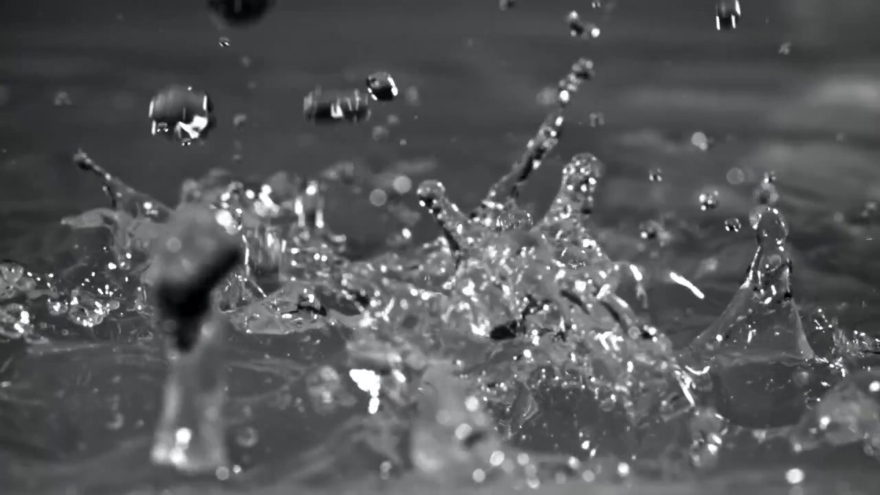 Slow Motion Water Drops Splashing on a Clear Liquid Surface