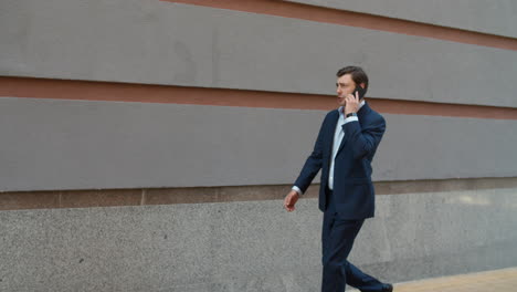 homme d'affaires ayant une conversation téléphonique dans la rue. homme allant au bureau