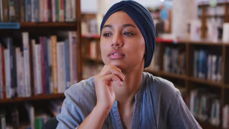 Estudiante-Asiática-Con-Un-Hijab-Azul-Pensando-Y-Aprendiendo-Su-Barbilla-En-La-Mano