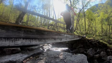 Male-trailrunner-with-backpack-is-running-over-small