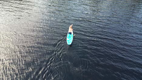 Aerial-View-Of-A-Man-Standup-Paddleboarding-In-The-Lake-In-Dalarna,-Sweden