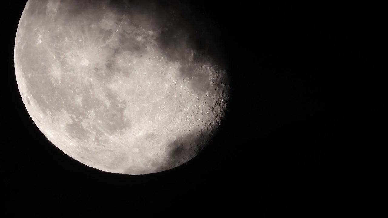 Close-up extremo da Lua sendo coberta por nuvens escuras, Cena noturna