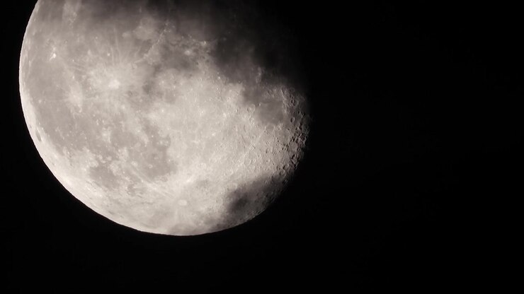 Close-up extremo da Lua sendo coberta por nuvens escuras, Cena noturna