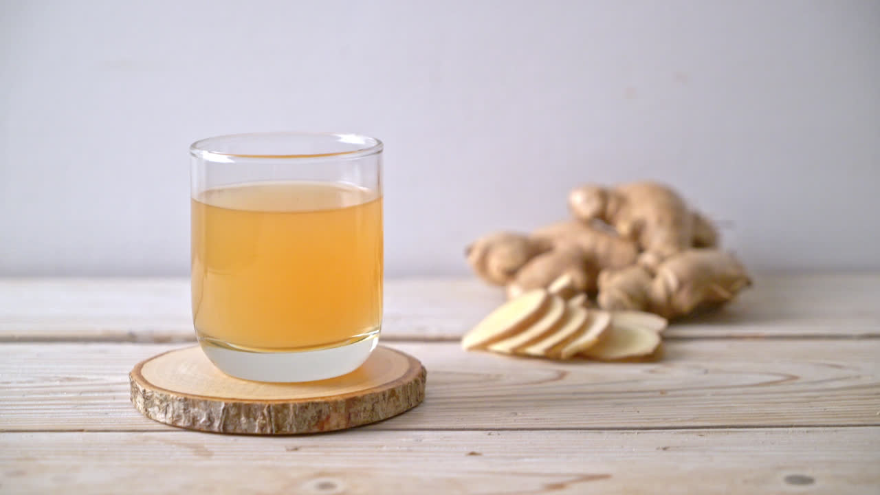 생강 뿌리가 있는 신선하고 뜨거운 생강 주스 유리 - 건강한 음료 스타일