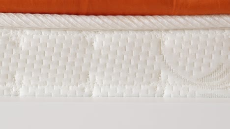 closeup of a white mattress with a rope border