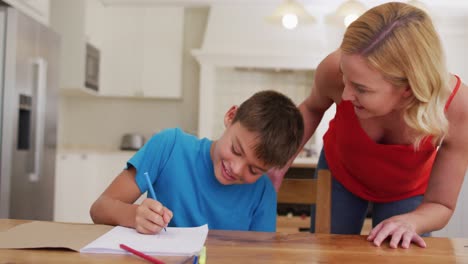 Kaukasische-Mutter-Hilft-Ihrem-Sohn-Bei-Seinen-Hausaufgaben-Zu-Hause