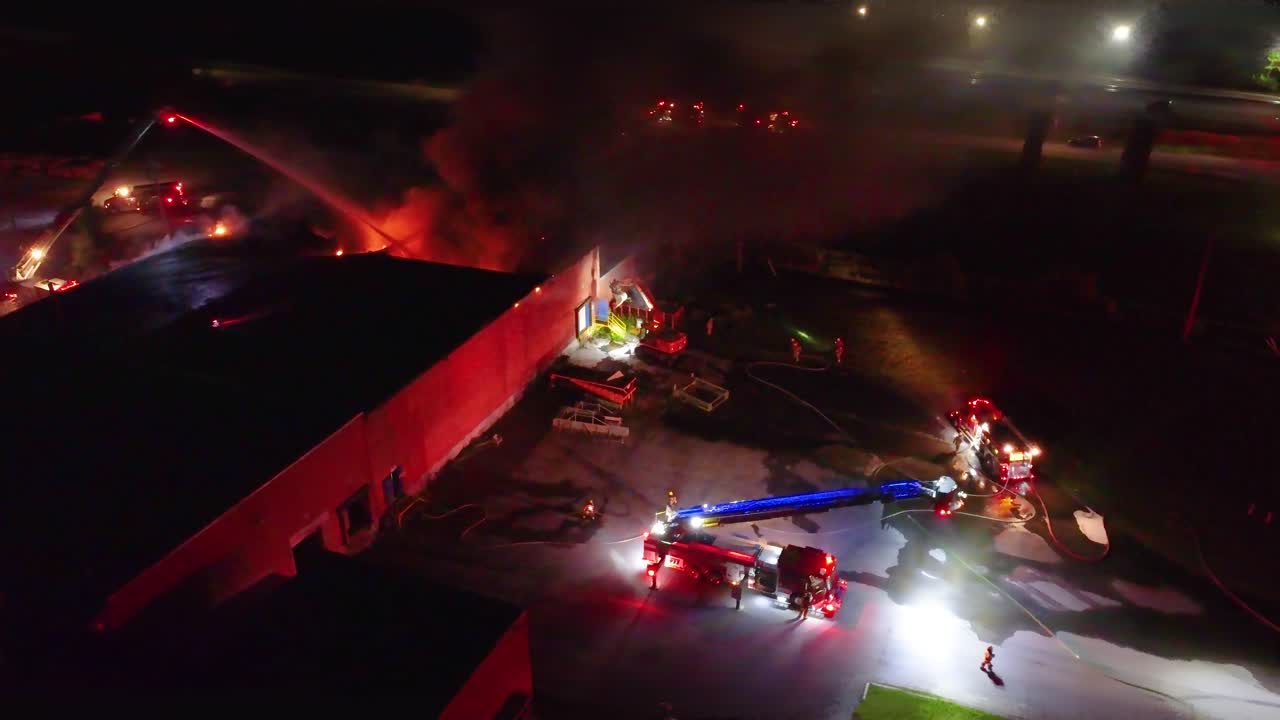 Firefighters extinguish a fire at night in Farnham, Québec. Aerial view.
