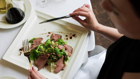 elegant woman eating meal in a restaurant