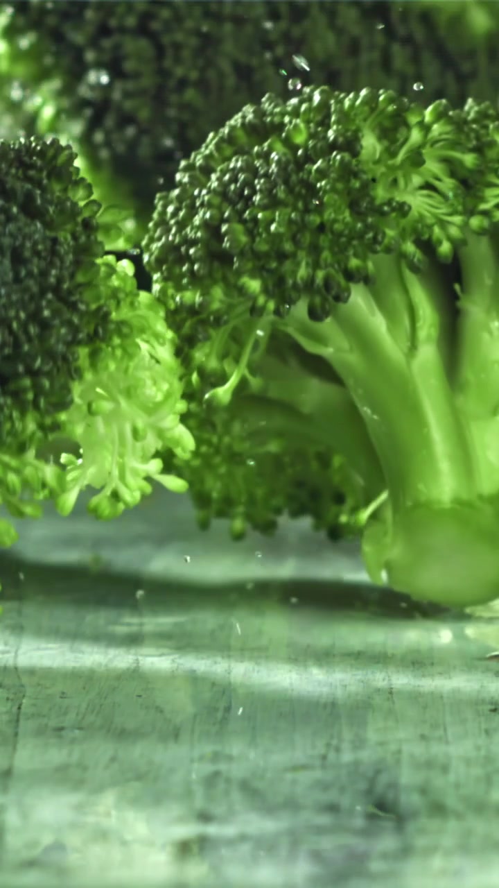 Cimette di broccoli freschi che vengono lavate con goccioline d'acqua