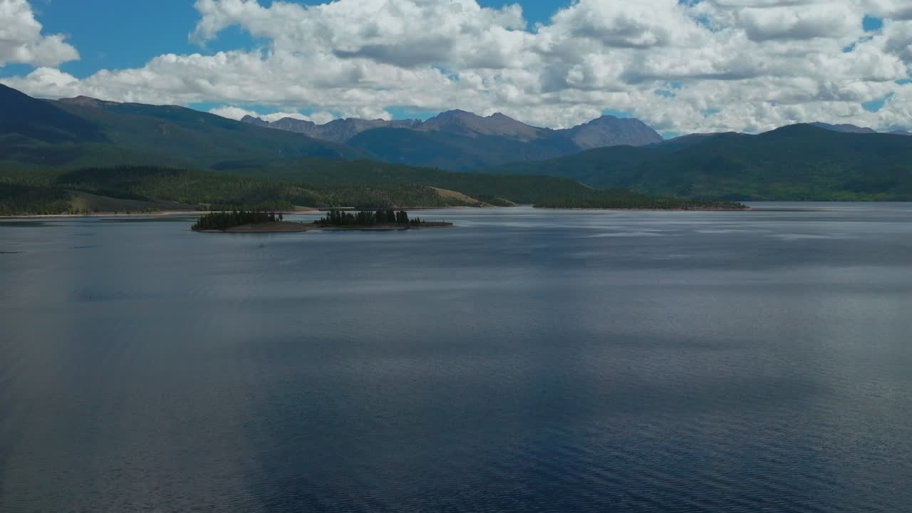 avión no tripulado cinematográfico de alta altitud gran lago sombra montaña abuelo colorado montañas rocosas entrada del parque nacional tranquilo claro hermosa mañana de verano navegación dos islas hacia adelante hacia arriba