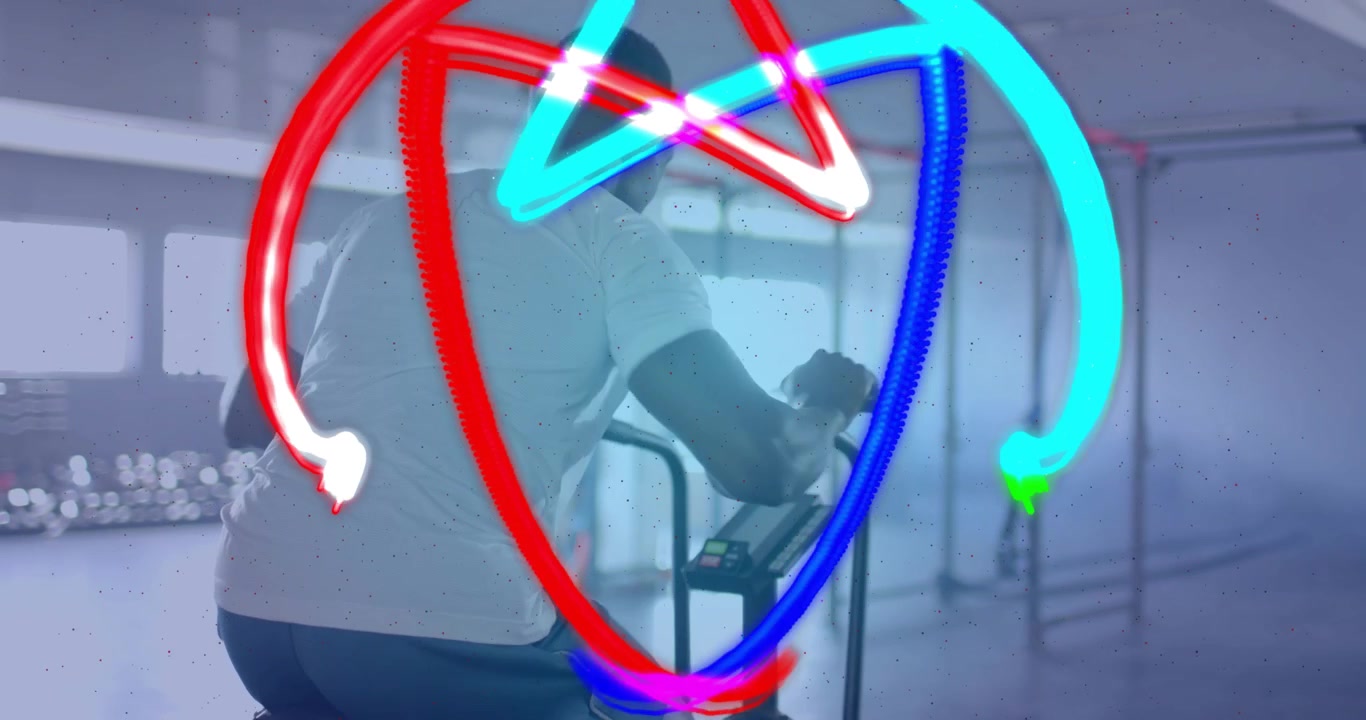Uomo che afferra le manopole della bici e pedala, creando scie al neon che formano motivi a stella per il fitness