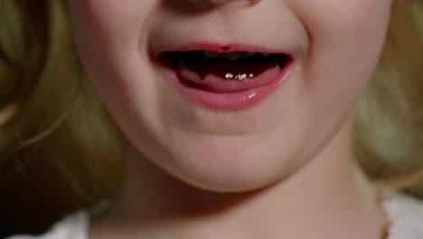 Playful teen child kid girl eating, licking melted chocolate sweet candy syrup from wooden spoon