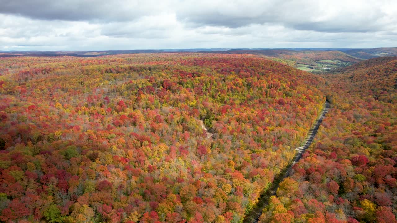 Peak fall colors in Northeast USA, scenic drive, aerial pan down