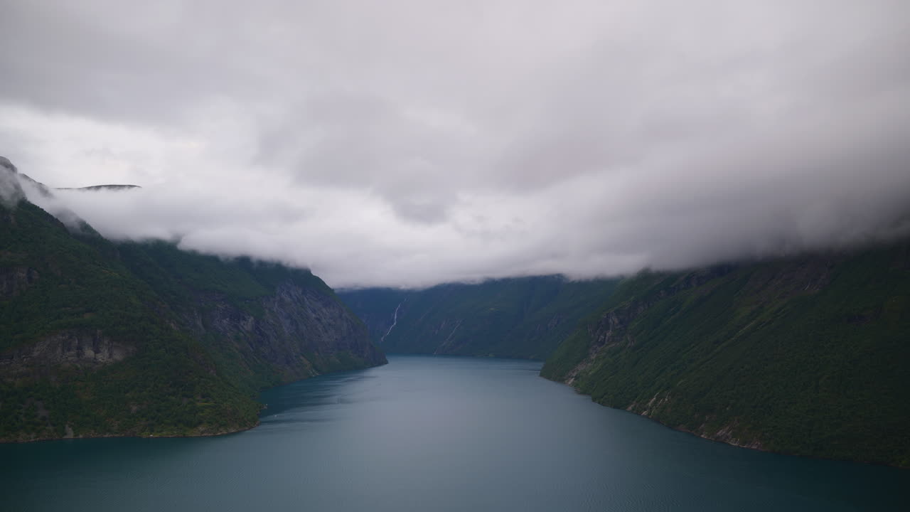 Landscape shot of Geirgangerfjord in Sunnmøre, Norway, The clouds are covering the mountain peaks