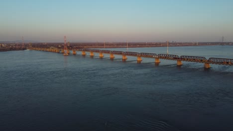 Aerial-shot-of-Victoria-bridge-with-a-passing-train-over-water