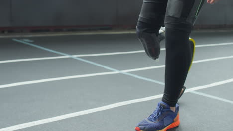 athlete with prosthetic leg running at stadium