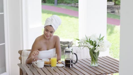 grinning woman at breakfast table outdoors