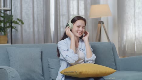 소파 에서 음악 을 즐기는 십대 소녀