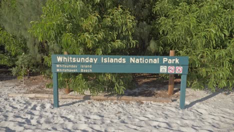 signage board of whitehaven beach at the sandy shoreline of whitsunday island, queensland, north australia