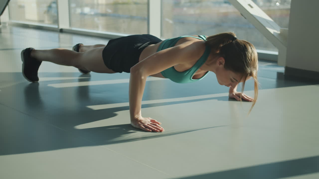 Woman performing push-ups in a gym