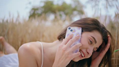 smiling girl calling cellphone laughing at summer picnic closeup. woman talking