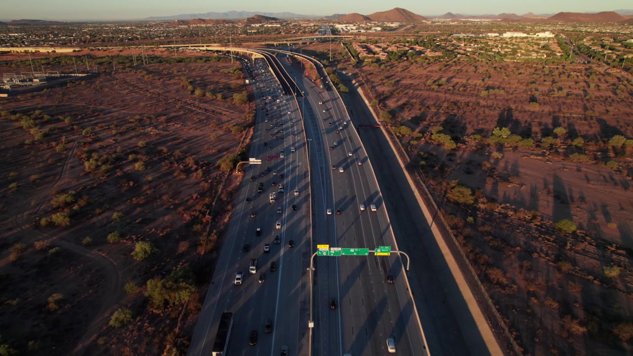 Rekaman drone miring yang keren dari jalan tol antarnegara bagian melintasi gurun Arizona, 4K