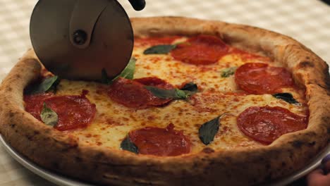 imágenes de cerca de cortar una deliciosa pizza italiana caliente, queso y salami