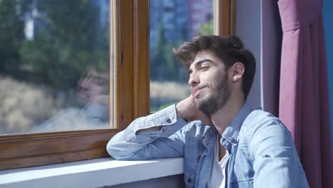 Hombre-Feliz-Y-Pacífico.-él-Está-Sentado-Frente-A-La-Ventana.