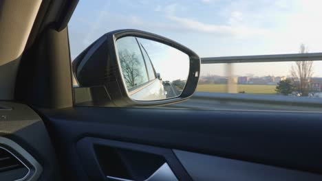 viajar por la carretera en italia: vista desde el espejo retrovisor, coches siguiendo y campo y panorama de la llanura de padana en el fondo - cámara lenta