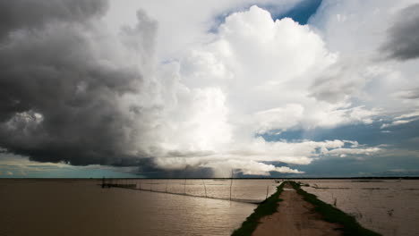 在東南亞的季風季節開始時, 雲端橫向滾動在tonle sap湖上方, 前景是魚網, 雨水移動.