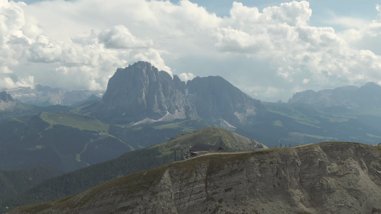 Luchtfoto met uitzicht op de Sassolungo; op de voorgrond een bergstation van een stoeltjeslift in Zuid-Tirol