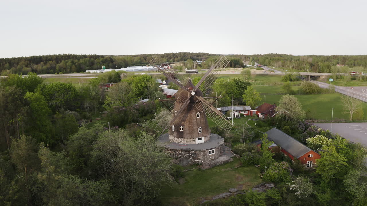 Wide aerial Drone shot moving around Sunvära kvarn Museum and windmill in Sweden.