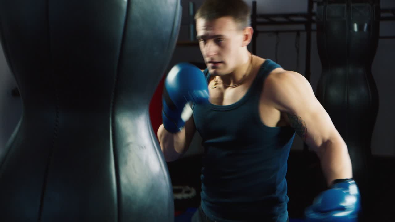 젊은 권투 선수가 펀칭 백에서 펀치를 연습합니다 2