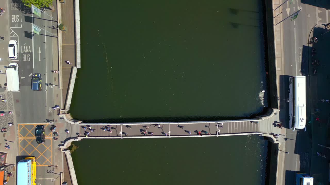 Reversing overhead aerial video of the Ha'penny Bridge and the River Liffey in Dublin City Centre, Dublin, Ireland on a bright and sunny day. Filmed in 4K, 60FPS and with Rec709 color.