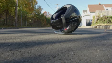 wide of a motorcycle helmet rolling on a street