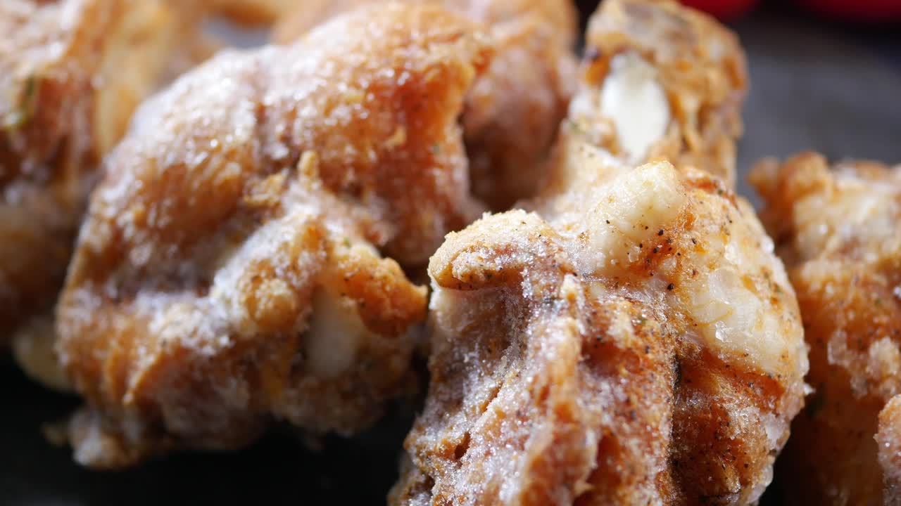Primo piano di pezzi di pollo surgelati e conditi.