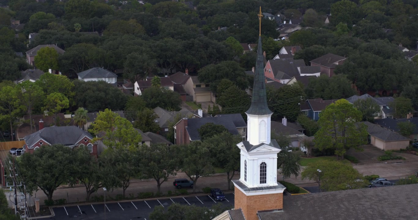 Teksas, Güneybatı Houston'da evlerle çevrili bir kilisenin drone görüntüsü