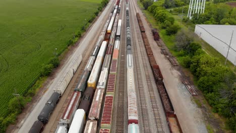 Vista-Aérea-De-4k-Que-Muestra-Varios-Trenes-Estacionados-En-Una-Estación-De-Tren-Esperando-Para-Salir