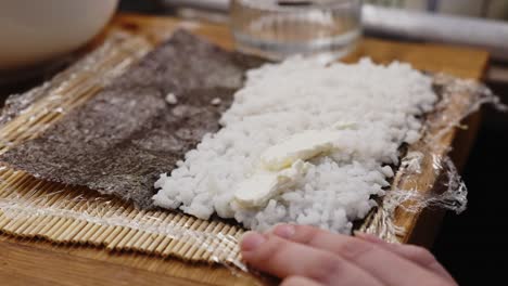 sushi preparing process with rice and seaweed