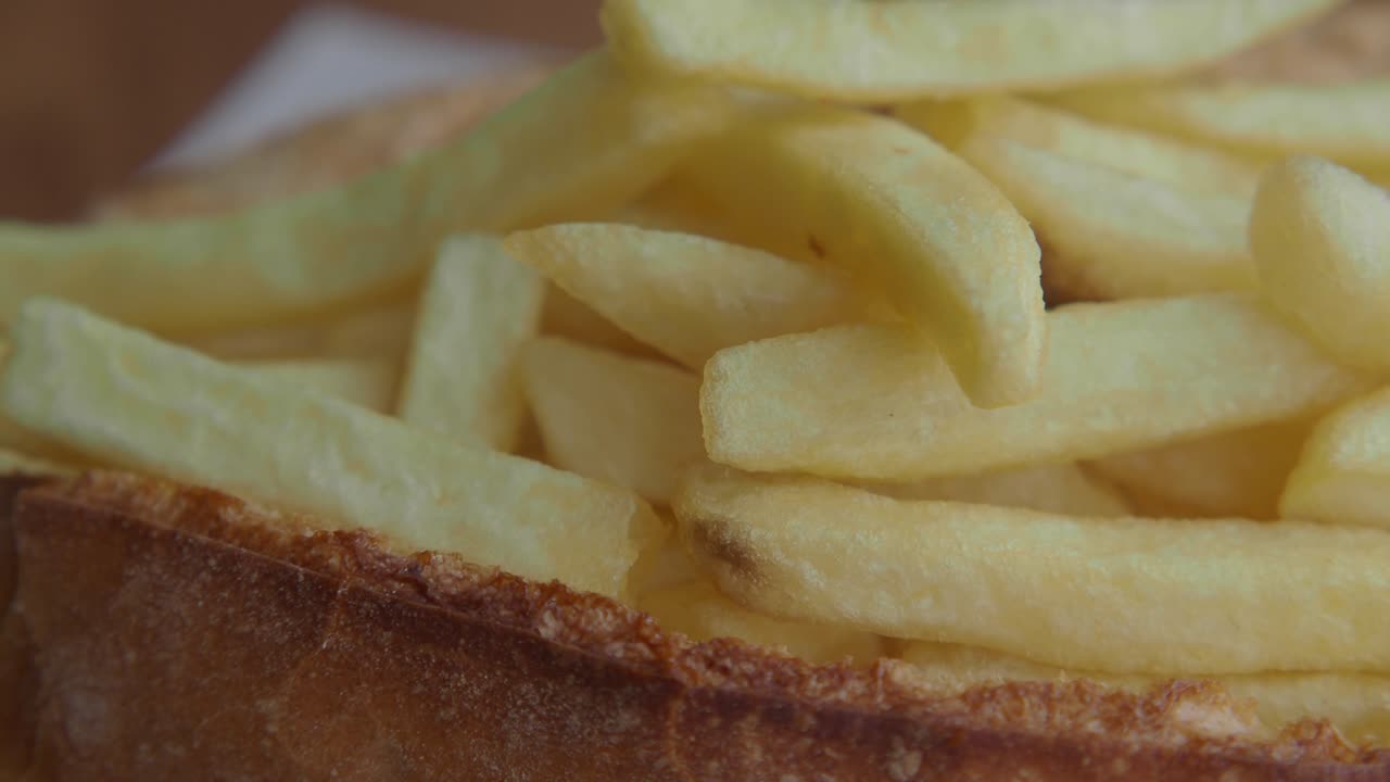 バンズに入ったきつね色のフライドポテトのクローズアップ