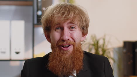 Businessman working at home office taking off glasses shocked by sudden victory lottery winning