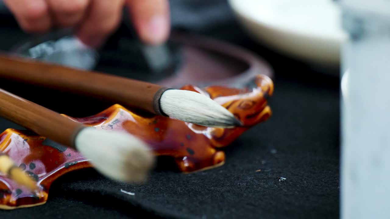 Footage of a Japanese Man Painting a Nihonga, a Traditional Japanese Painting, with Brushes and Black Ink