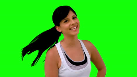 woman in sportswear tossing her hair on green screen