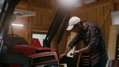 farmer repairing a tractor in a barn