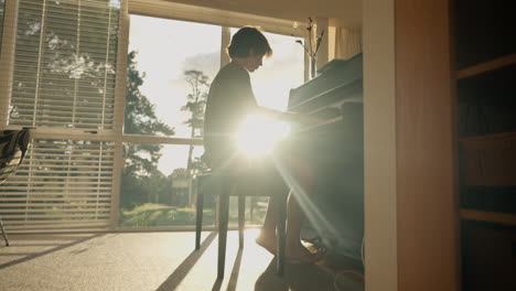 young boy plays piano at home