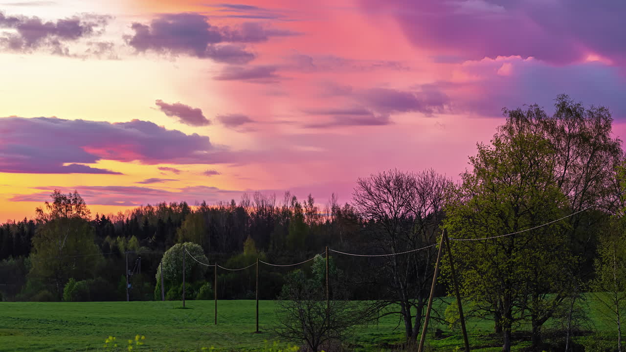 lapso de tiempo de nubes de colores violeta rosa en movimiento en el cielo en el paisaje rural