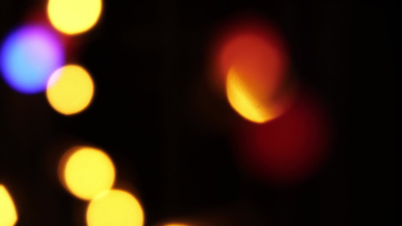 Abstract bokeh background in motion. shining, blurred multicolored particles, lights. bright bokeh from garlands on dark background. New year or Christmas festive backdrop