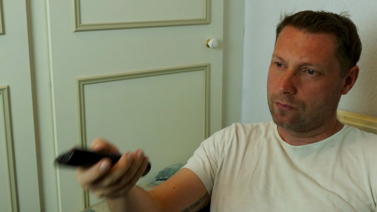 Mand zapper rundt mellem kanalerne hjemme